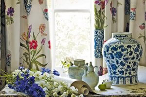 An image showing flowers on a table with a vase in front of some beautiful curtains in Sutton Coldfield