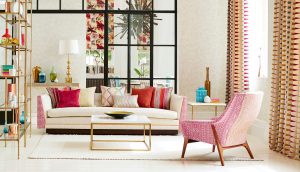 An image showing a bright modern room filled with various soft furnishings and an interesting pair of colourful print curtains